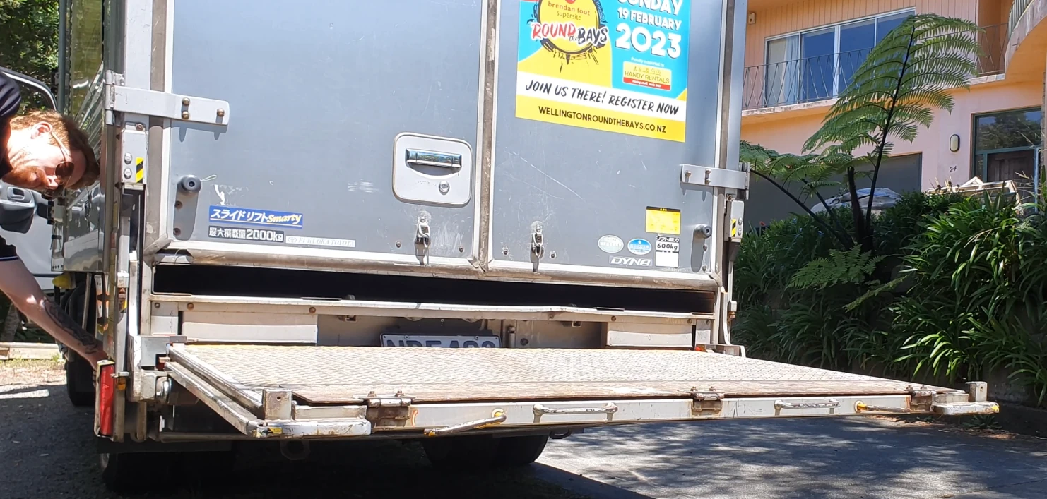 Using the up and down buttons on a box body moving truck to operate the tail gate