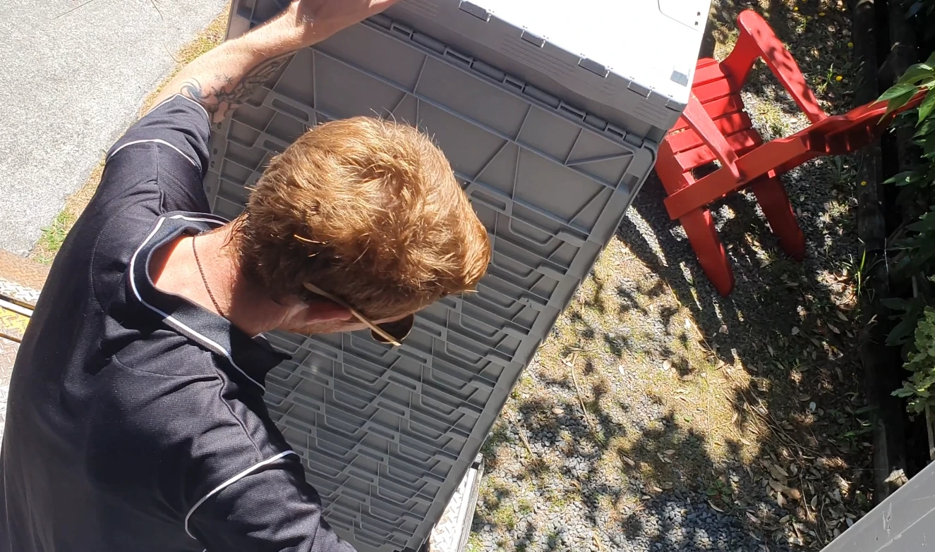 Handy rentals staff member using the tail lifter on a small moving truck