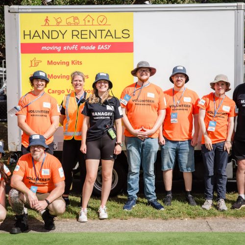 Organisers and volunteers standing with a Handy Rentals truck