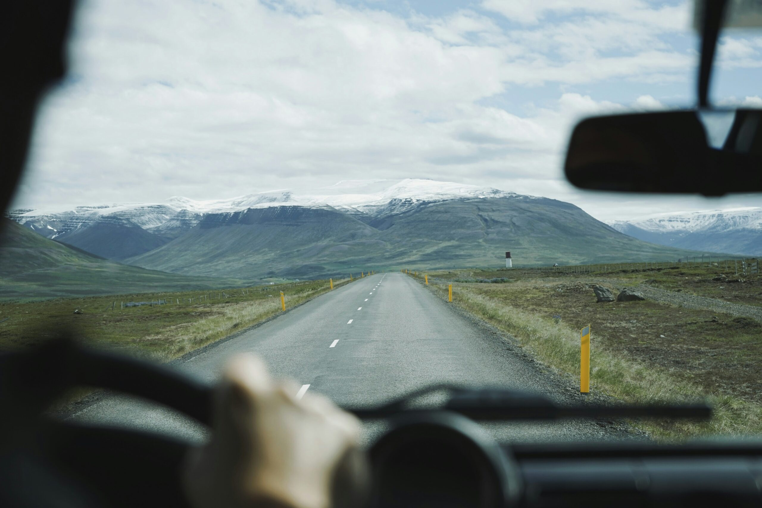 Hands on steering wheel of vehicle driving on road